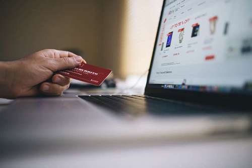  Persona comprando en tienda electronica con tarjeta de credito desde su laptop