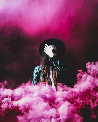 Mujer en fondo de humo rosa 
