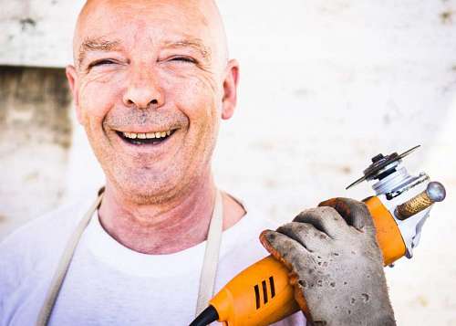 personal primer plano de un hombre calvo sosteniendo una moladora