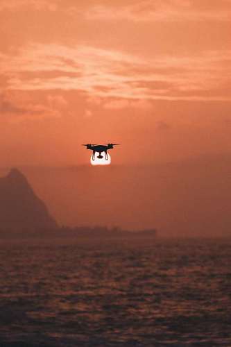 zumbido Drone volando sobre el mar al atardecer