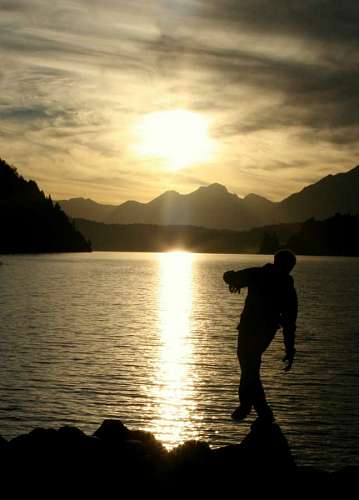 equilibrio Hombre haciendo equilibrio sobre las rocas con lago de fondo