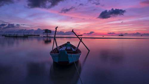 Bote con remos en una bahia al atardecer