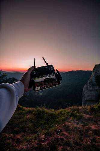 video Una Persona Sosteniendo un Control de Drone al Atardecer