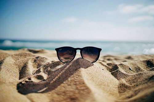 fondos de pantalla 4k Gafas de sol en la arena de la playa
