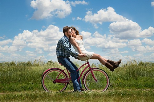 Feliz pareja de jóvenes en bicicleta 