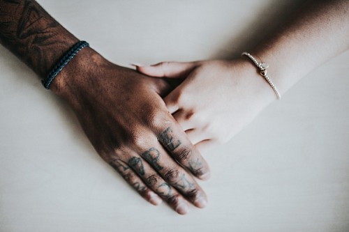Pareja de la mano con tatuajes