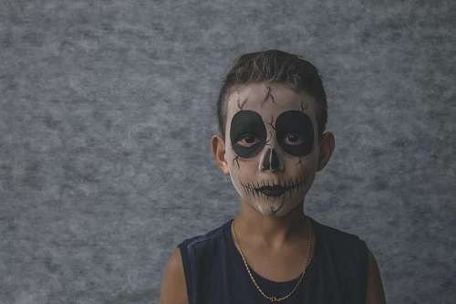 mexico Niño con la cara pintada en dia de muertos 