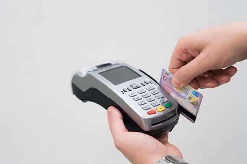 Tarjeta de credito pasando por lectora en local de compras 