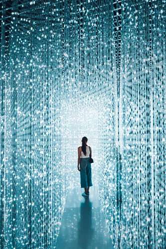 wallpaper de mujer caminando a través de una pasarela con luces brillantes