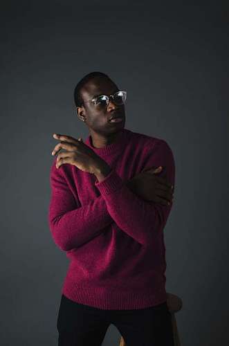 hipster Hombre con gafas y sweater rojo posando 