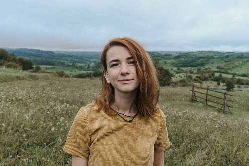Retrato de una joven pelirroja mirando a la camara en el campo