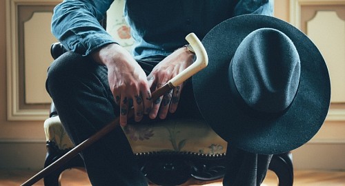 a la espera Hombre elegante de manos tatuadas 