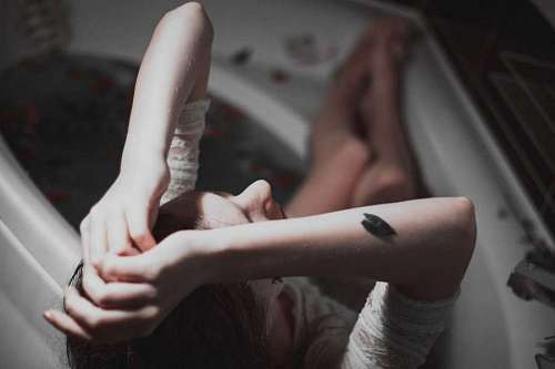 acostado Mujer llorando en la bañera