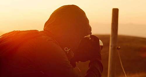 hipster Fotografo tomando fotografías en el atardecer 