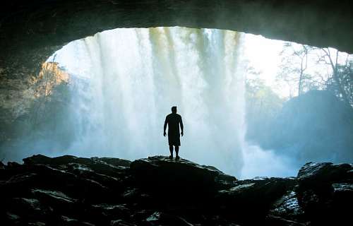 Hombre explorando una cascada en el bosque