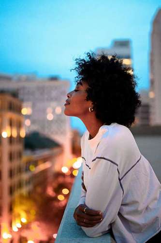 afro Mujer joven suspirando desde el balcon