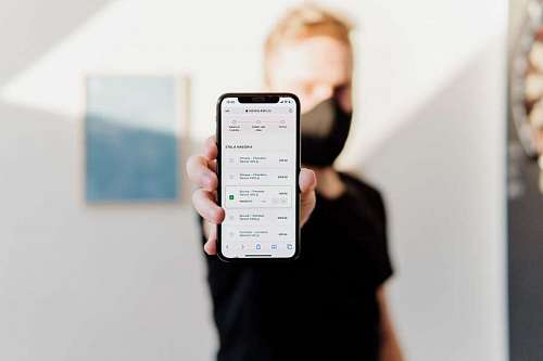 boton primer plano de celular sostenido por un hombre de fondo