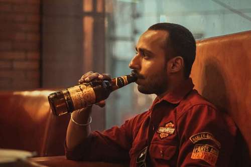 primer plano de un hombre bebiendo cerveza solo mientras está sentado