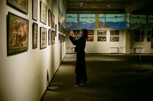 distancia Una mujer mirando cuadros en un museo
