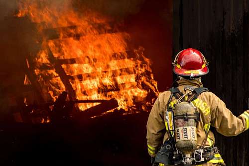 bombo bombero parado frente a un incendio