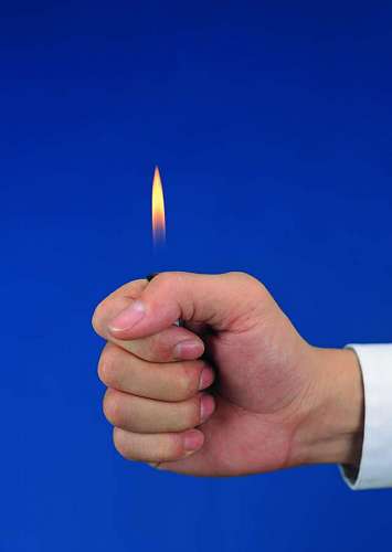 en una fila primer plano de una mano con un encendedor y un fondo azul