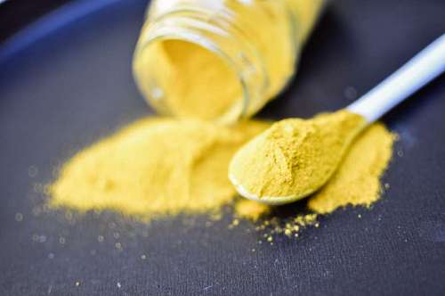 Montón de polvo de curcuma aislado sobre fondo negro
