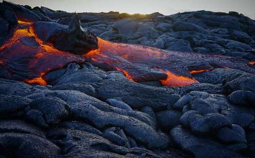 volcan o primer plano de lava volcanica con puesta de sol de fondo
