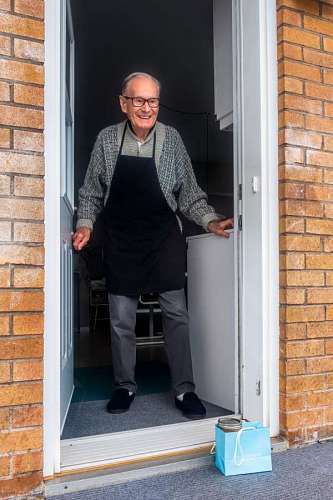 hombre de avanzada edad recibiendo un regalo durante el distanciamiento social
