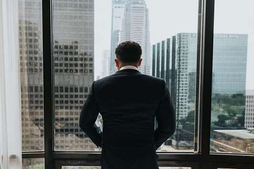 ejecutando Hombre de negocios mirando por la ventana