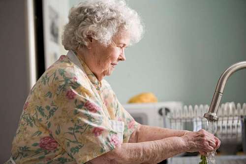 envejecimiento Mujer Anciana lavando las verduras antes de cocinarlas