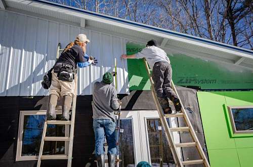 personal albañiles pintando una casa de verde
