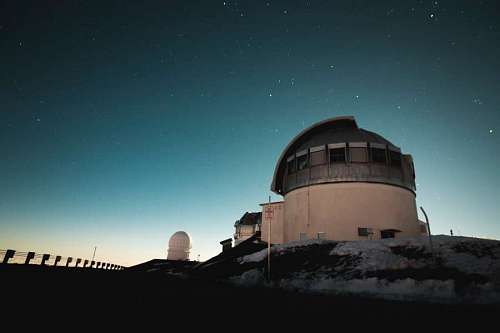 Observatorio astronomico con cielo estrellado de fondo