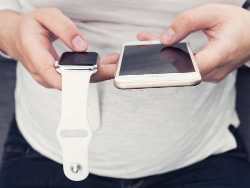 conectividad Mujer usando el telefono y el smartwatch