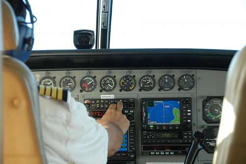 Piloto de avion calibrando instrumetos de navegacion en la cabina de vuelo