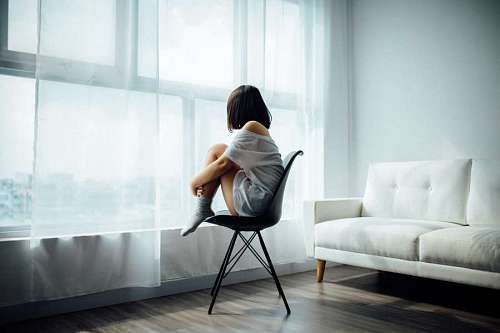 tristeza Mujer joven triste sentada frente a la ventana