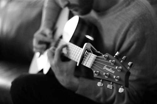 Hombre tocando la guitarra en blanco y negro