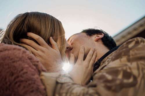 una pajera de novios besándose bajo el rayo de sol