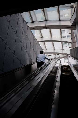 hombre solitario subiendo por escalera mecánica