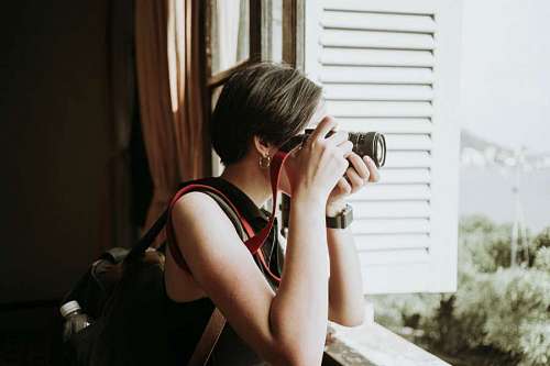 copyspace Mujer fotografa tomando imagenes desde la ventana