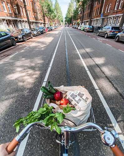 las leas Una persona llevando las compras de vegetales y leche en su bicicleta