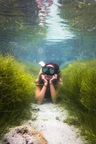 extremo Mujer posando mientras hace snorkel en un arrecife