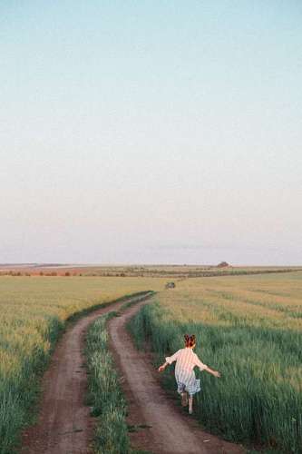 luz del sol Niña corriendo por una camino de campo