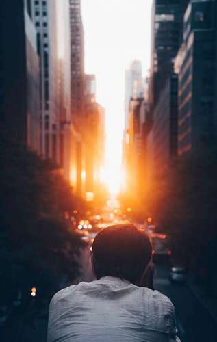 masculino Hombre tomando una fotografia durante el atardecer en una ciudad