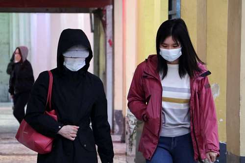 cuidado de la salud dos mujeres asiaticas caminando con barbijos 