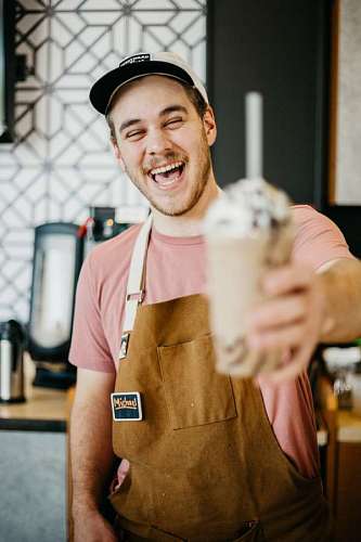 empleado primer plano de un empleado de starbucks sosteniendo un batido