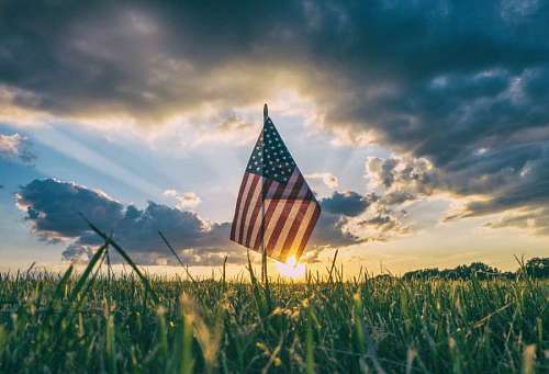 Bandera de Estados Unidos al atardecer en un campo
