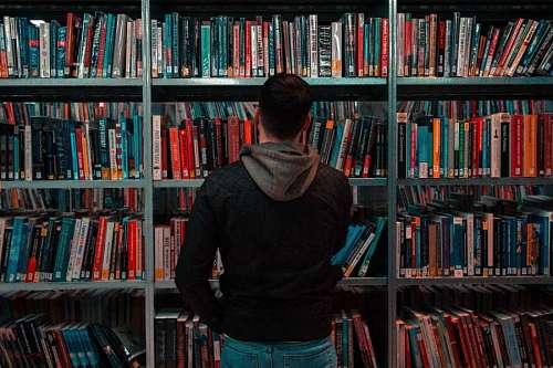 chico parado frente a estante de librería
