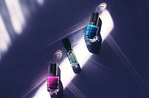 Tres botellas de esmalte de uñas de colores surtidos en la superficie
