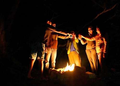 excursionista Grupo de personas brindando en un fogon en la playa a la noche