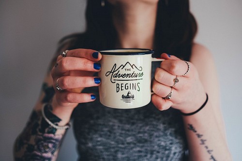 tatuajes Joven chica tatuada sosteniendo una taza